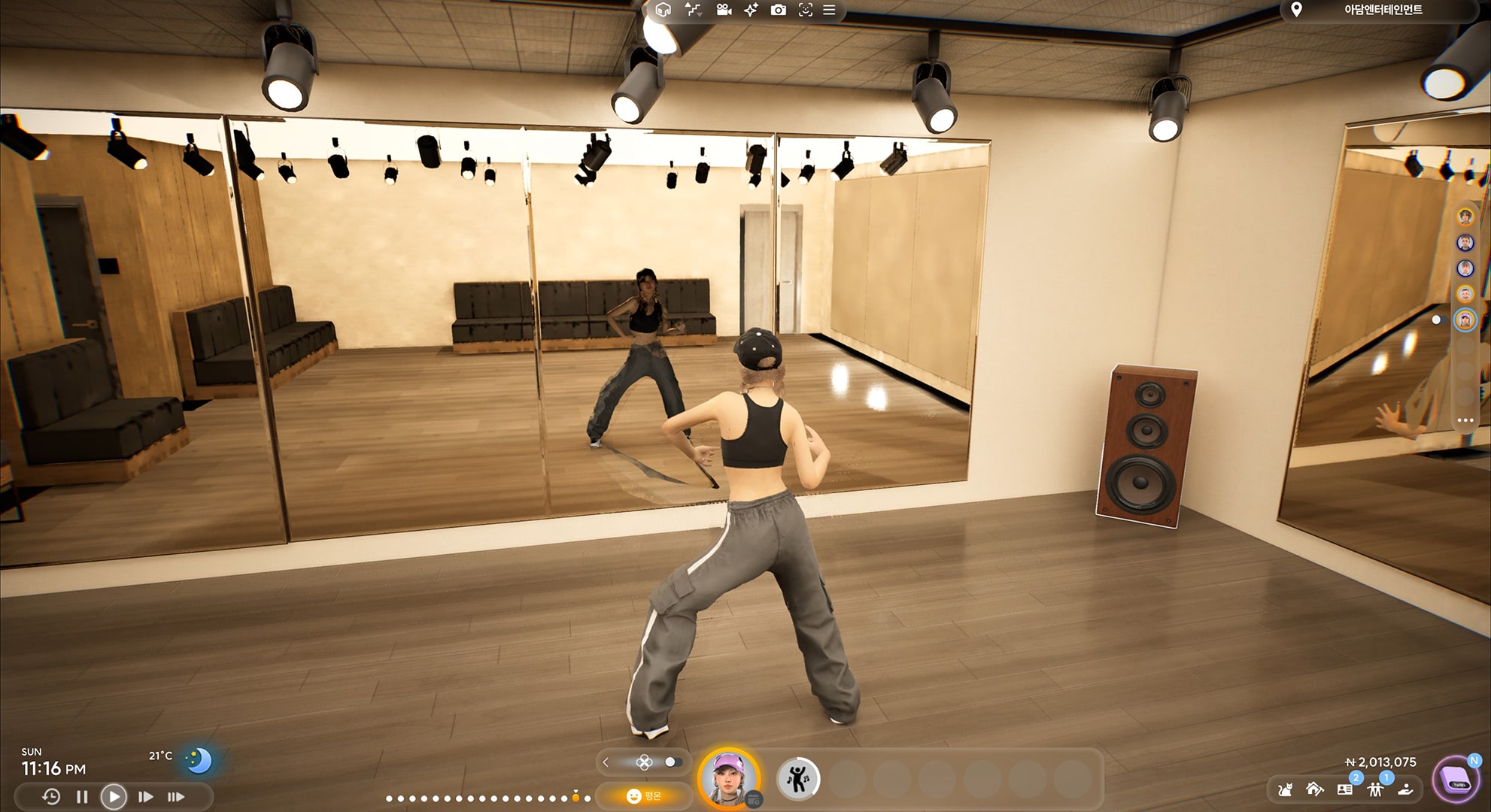A gameplay scene from InZoi, featuring an in-game character practicing choreography in a mirrored dance studio. The environment includes wooden floors, spotlights, wall-length mirrors, and a visible speaker. Interface elements display time, temperature, and in-game currency.